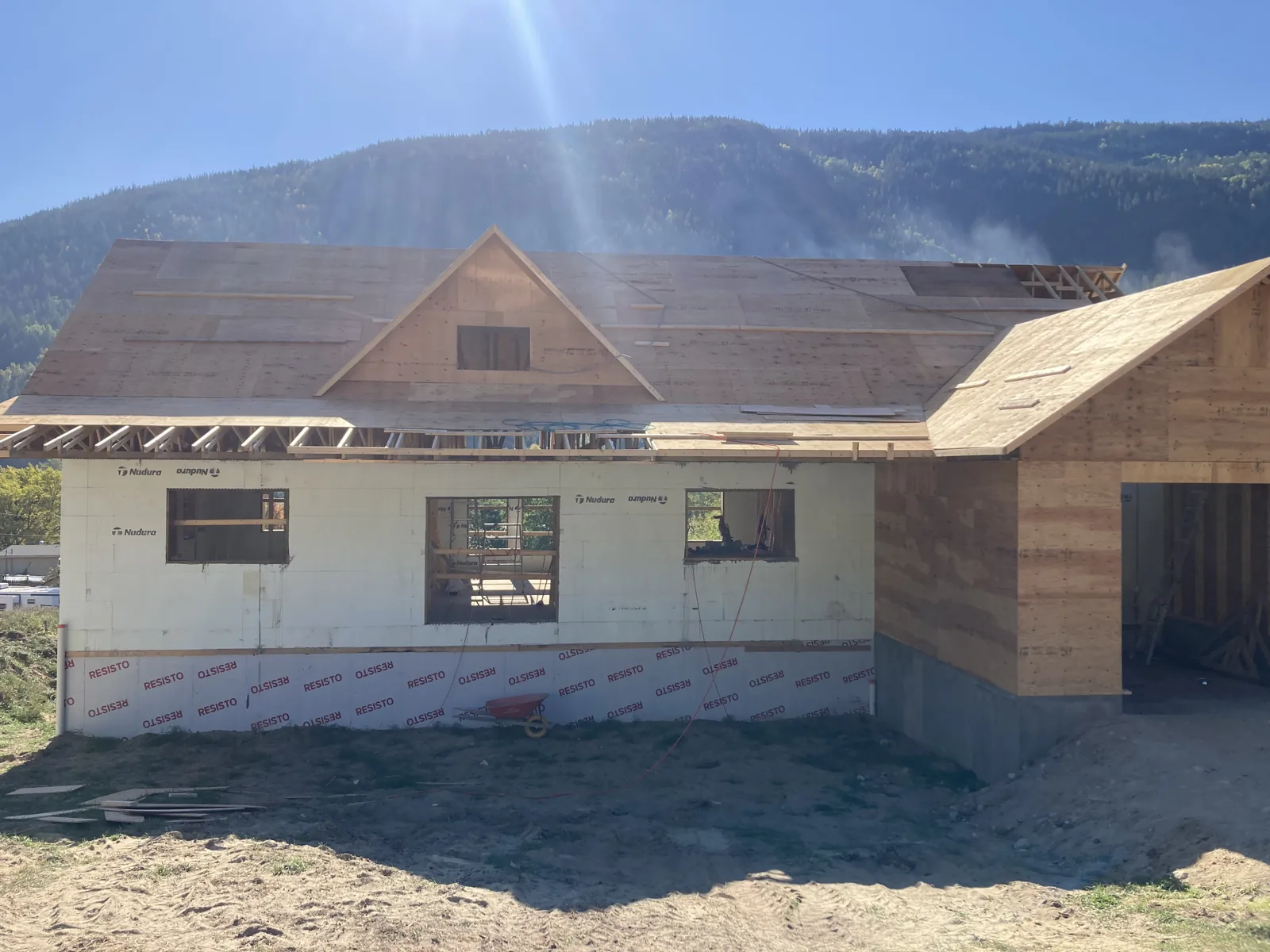 House under construction with roof sheathing and exterior wall wrap