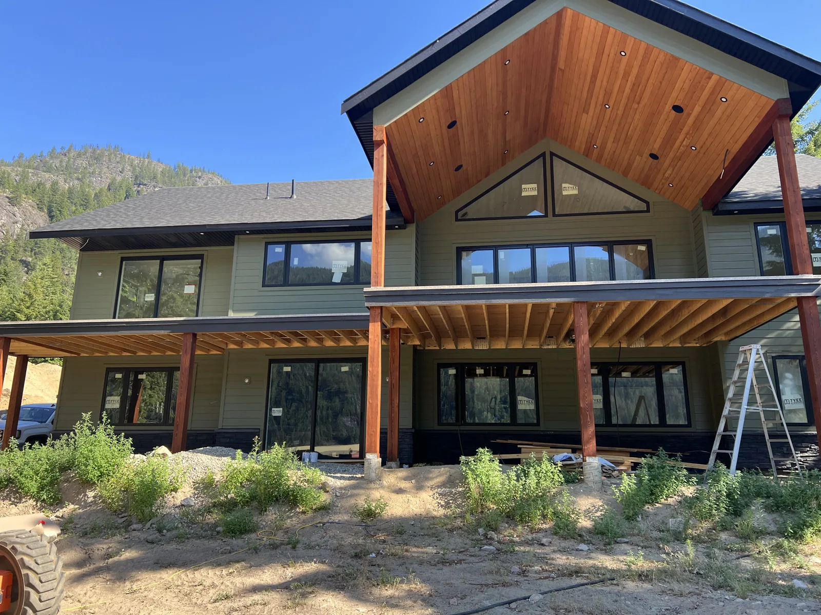 Home exterior with a tall timber-lined covered entry and siding